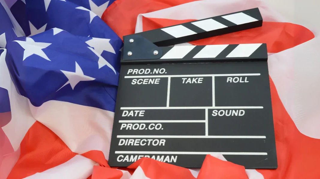 American flag draped beneath a film clapperboard symbolizing patriotic moments in American cinema.