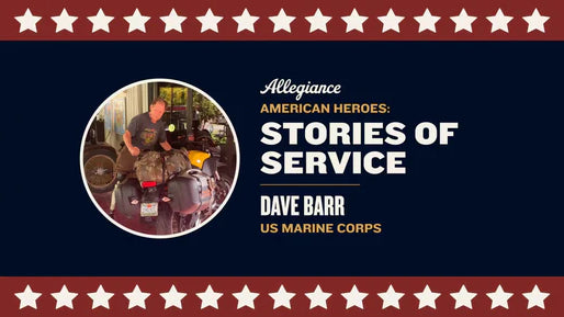 Dave Barr, a US Marine Corps veteran, standing beside his packed motorcycle in a garage or outdoor space