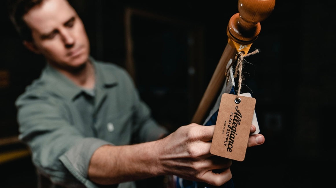 A 3x5 American Flag on the side of a brick home.