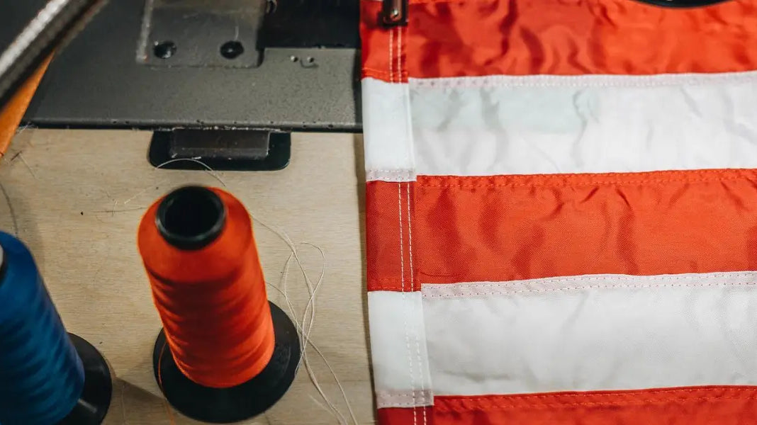 USA flag store sewing station with red and white flag stripes next to red and blue thread spools