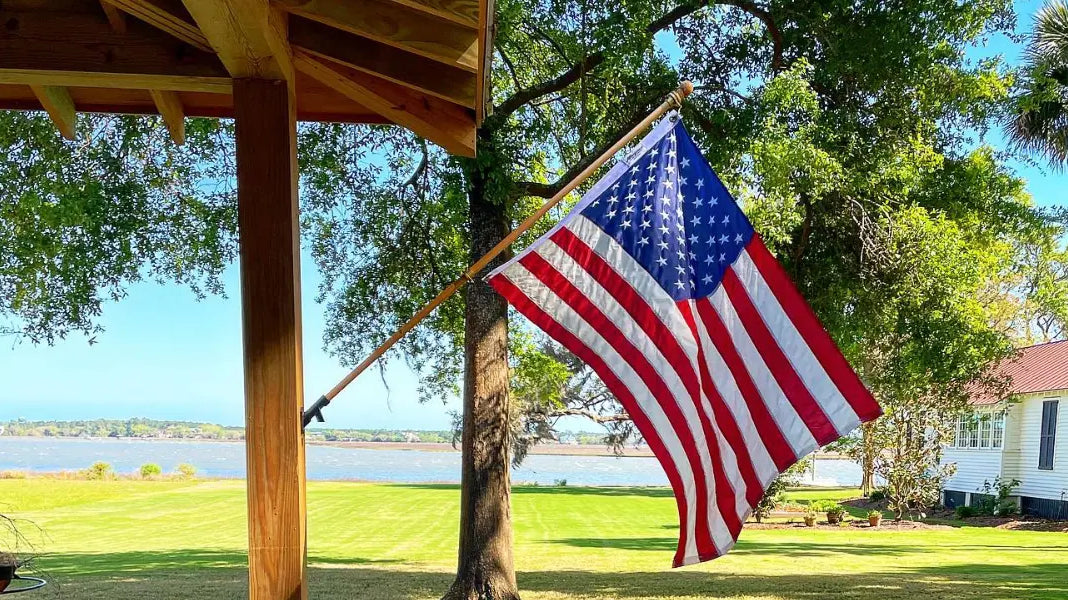 An American flag mounted on a wooden post waves in the breeze, highlighting proper flagpole maintenance for longevity.