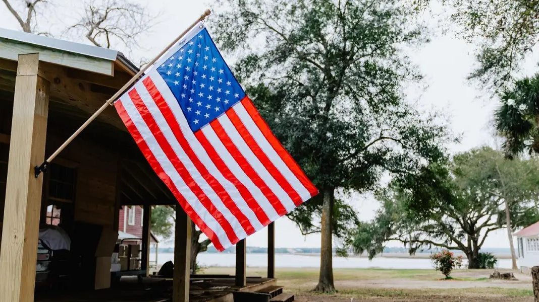 A half-staff flag display is not shown, but this American flag mounted on a wooden post follows respectful flag practices.
