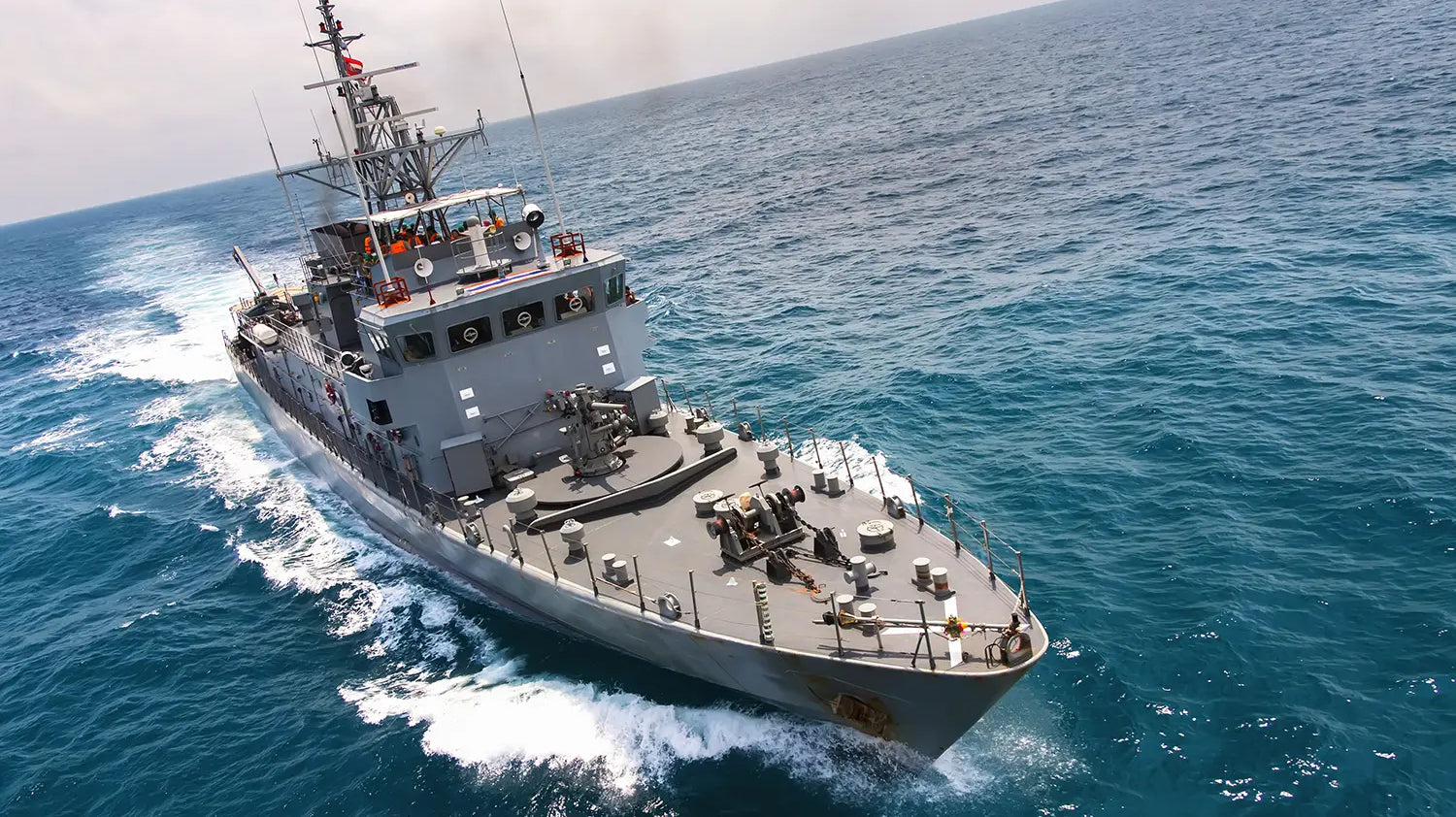 US Navy carrier sailing through the open ocean.
