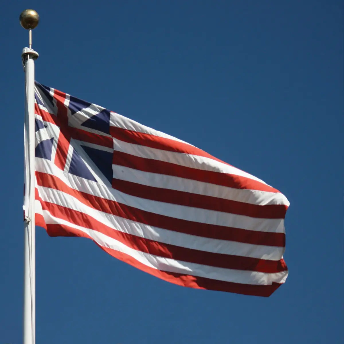Continenal Union Flag waving on a flagpole against a bright blue sky
