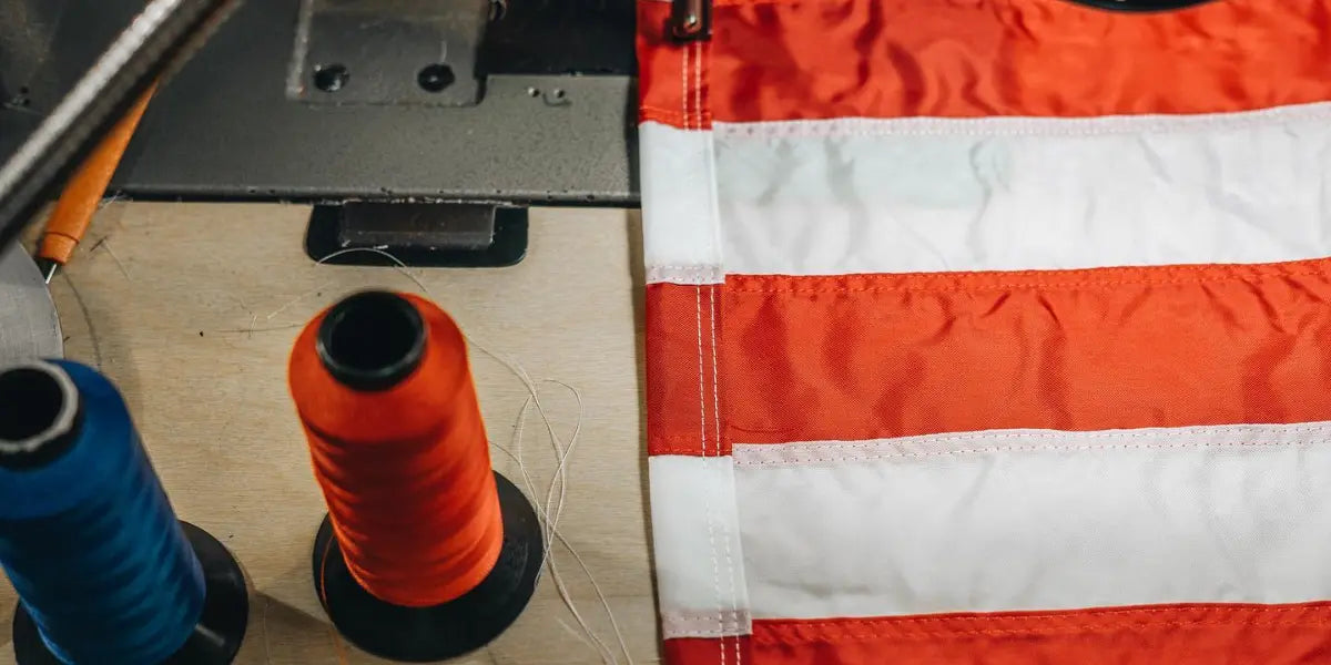USA flag store sewing station with red and white flag stripes next to red and blue thread spools