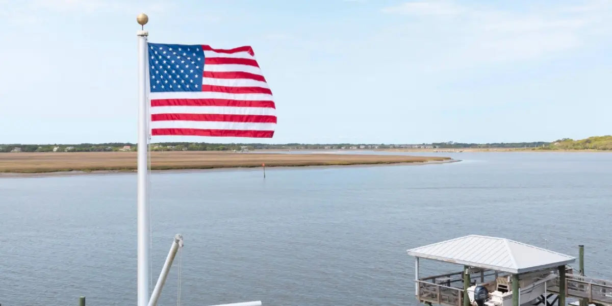 Custom boat flag wave from a white pole on a motorboat deck under a clear blue sky